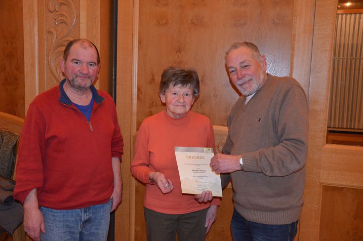 Rainer Fleuchaus und Erich Perchermeier überreichen Gerda Follmer Urkunde und Ehrennadel