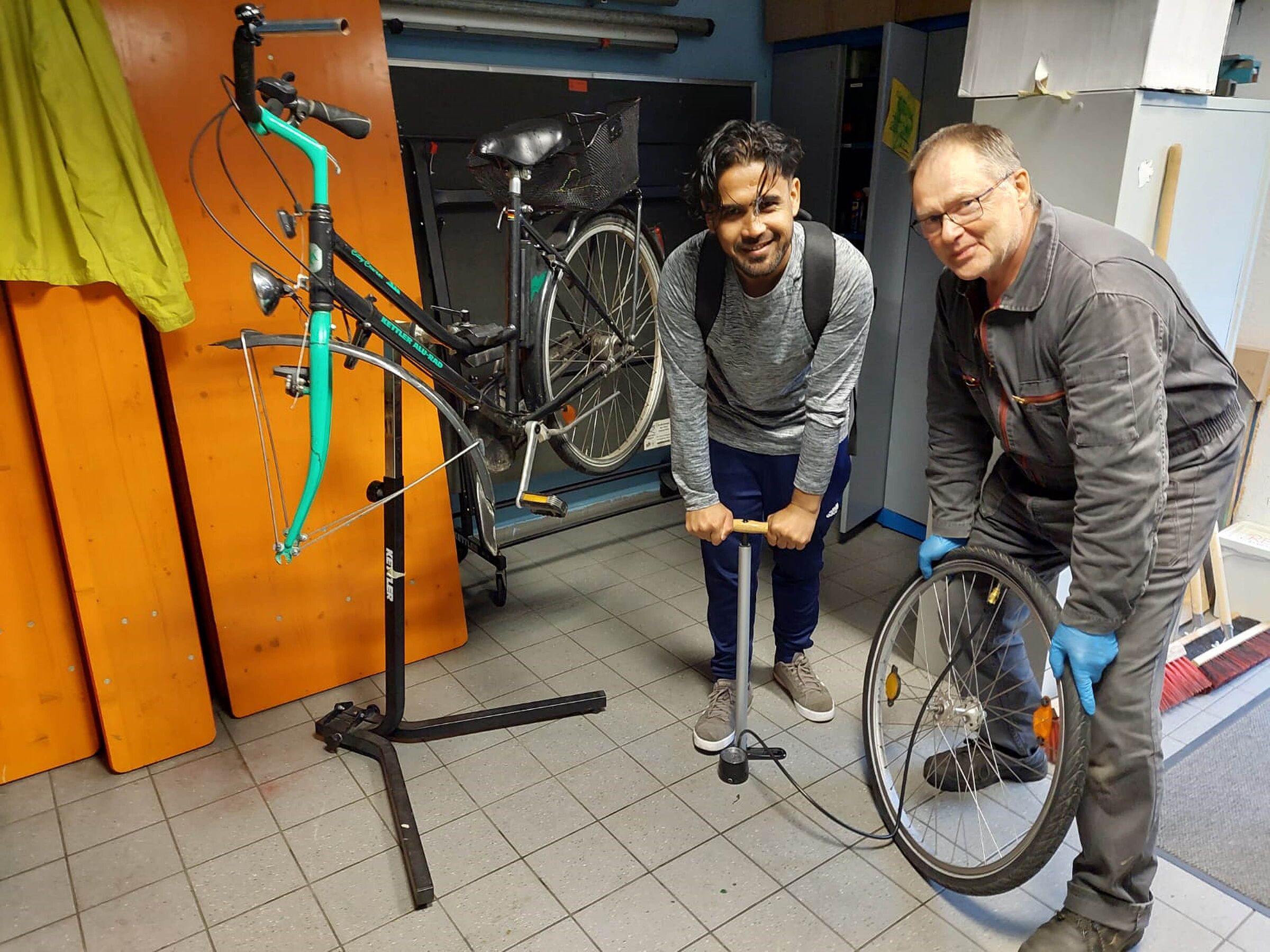 Gemeinsam mit dem Besitzer des Fahrrads setzt Bernhard Bröstler im Repair Café ein älteres Fahrrad instand, Foto Stephanie Namyslo